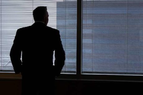 Business exit plan questions with man contemplatively looking out window.