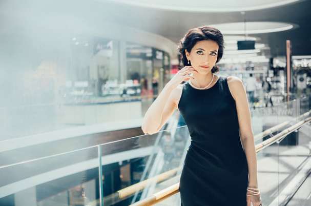 Pay Gap Can Lead to a Retirement Gap With Business Woman Standing Near Stairs in Office