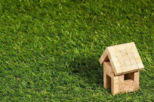 Inherit a home image shows a toy block wood home on grass