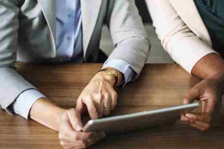 Should You Consolidate Your Retirement Accounts? Image of professionals using tablet for analysis.