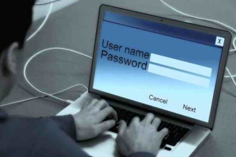 Password Manager Image of Man Typing User Name and Password on Laptop