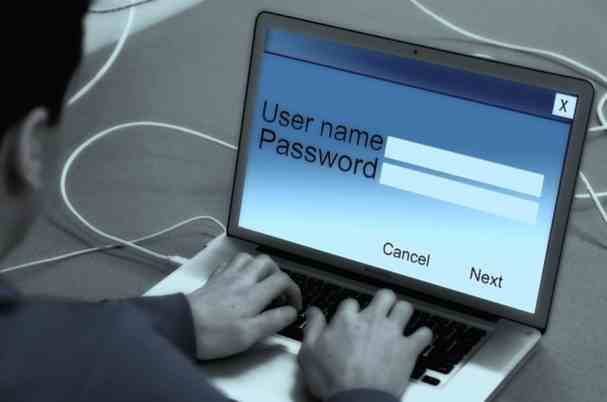 Password Manager Image of Man Typing User Name and Password on Laptop