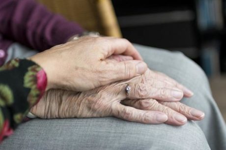 Financial exploitation picture of elderly woman with younger woman holding her hand