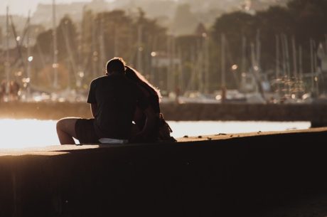 Planning guide for unmarried couples depicts man and woman hugging as they sit on a pier.