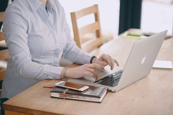 Nonqualified deferred compensation plan shows woman sitting at desk typing on computer.