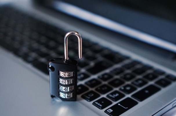 Browser security shows lock standing on a laptop keyboard.