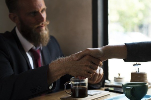 Buy-sell agreement with business owners shaking hands.