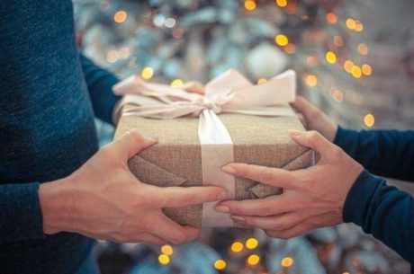 Charitable gifting image depicts a man and woman holding a present.
