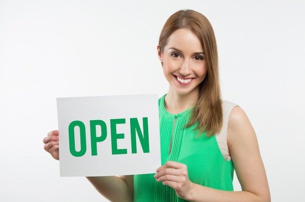 Retirement plan sponsors with woman holding an open sign.