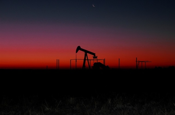 Commodities Primer Image of oil pump in field at sunset.