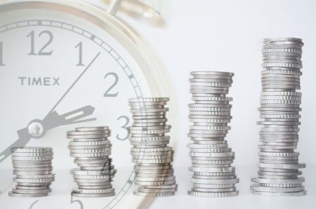 Retirement Account Rule Changes with stacks of coins in front of clock.