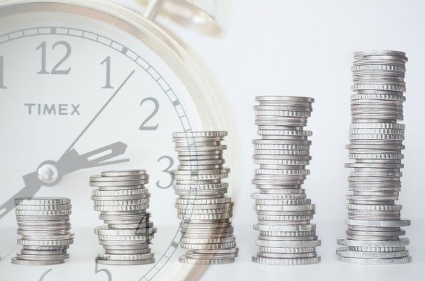 Retirement Account Rule Changes with stacks of coins in front of clock.