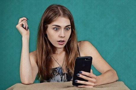 Devising a Data Breach Game Plan Shows Young Woman Looking with Shock at Mobile Phone.