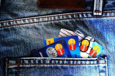 Managing Your Credit Score depicts multiple credit cards sticking out of jeans pocket.