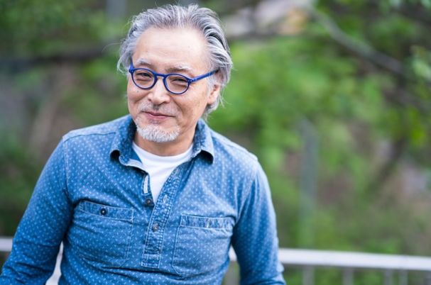 Preparing for Medicare enrollment image shows elderly man smiling at camera.