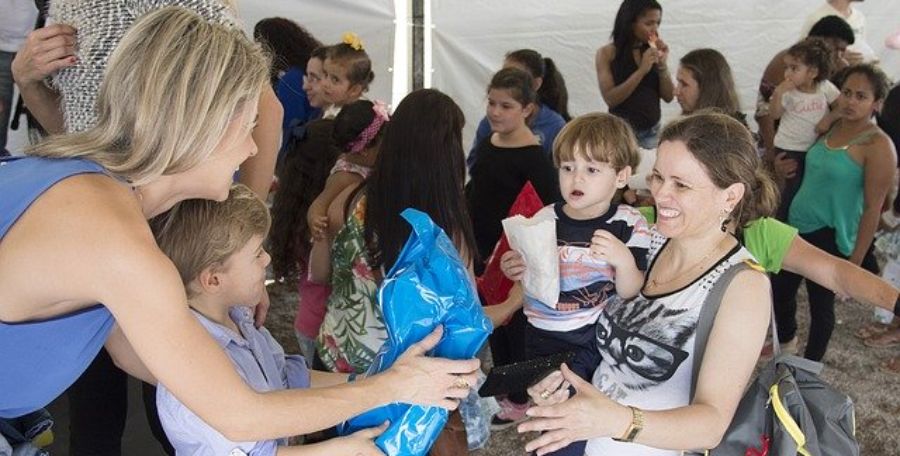 Charitable giving tools depicts a woman and son handing care package to another woman holding a toddler.