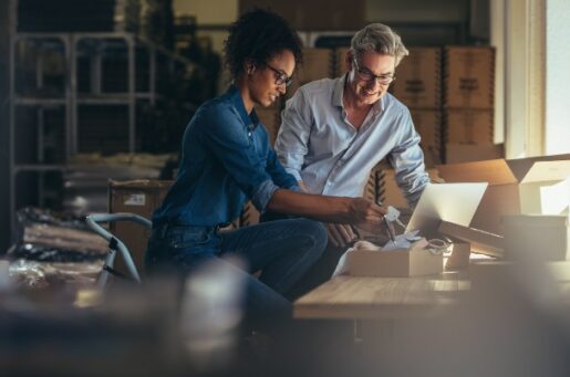 Financial planning for small business owners shows man and woman working in warehouse.