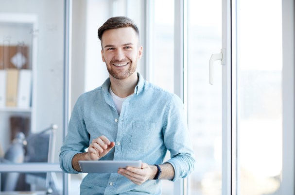 Effects of compound interest depicts young man holding a tablet.