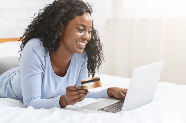 Woman on Laptop Holding a Credit Card.