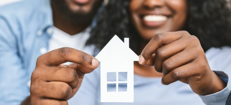 Mortgages and refinancing shows man and woman holding a house cutout.