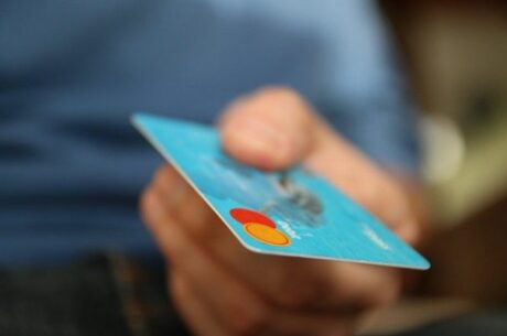 Guide to protecting your credit concept photo with man holding a credit card while making a purchase.