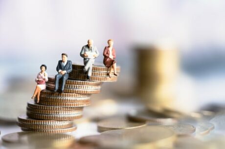 Social Security Benefits for Divorced Couples depicts elderly people sitting on coin stacks.