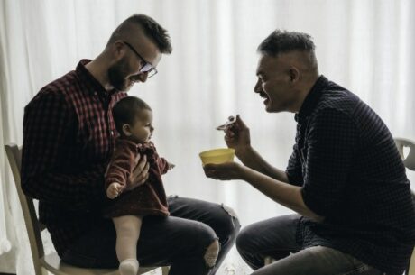 Estate Planning for LGBTQIA+ Married Couples with Two Married Men Feeding Their Baby.