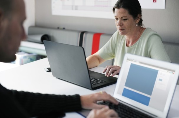 Choosing an entity for your business photo shows business man and woman working on laptops.