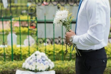 Death of a Spouse or Partner With Man Carrying Flowers in Cemetery.