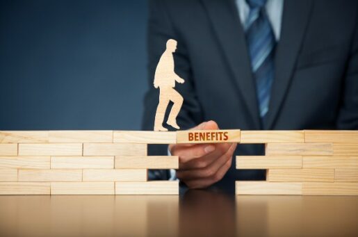 Making the Most of Employer Sponsored Plans Depicts Business man Holding Wood Black that Says Benefits photo of wood man walking across wood block that says benefit on it..