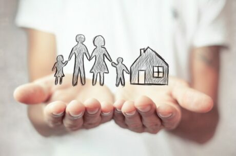 To Buy or Not to Buy . . . When Do You Need Life Insurance? Image shows hands protecting family and house.