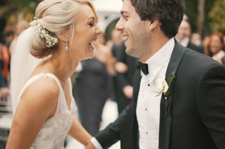 wedding finances survival guide with husband and wife holding hands and laughing.