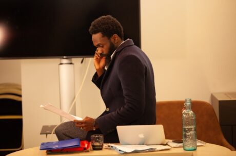 Choosing Your Executor or Trustee photo of trustee man sitting on a desk while talking on the phone and reading a document.