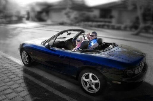 Preparing for retirement depicts elderly man and woman driving off in a blue convertible.