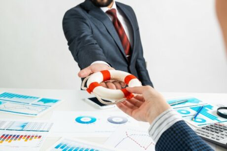 Benefits of Business Insurance Shows Insurance Agent Handing Business Owner a Water Lifesaving Device
