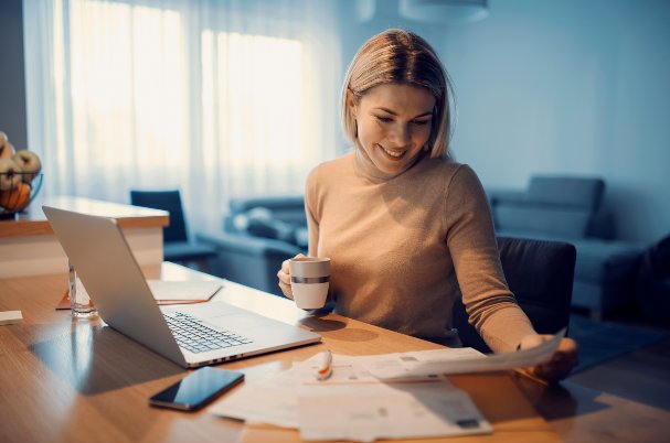 Woman with coffee looking at documents and considering securities-based lending