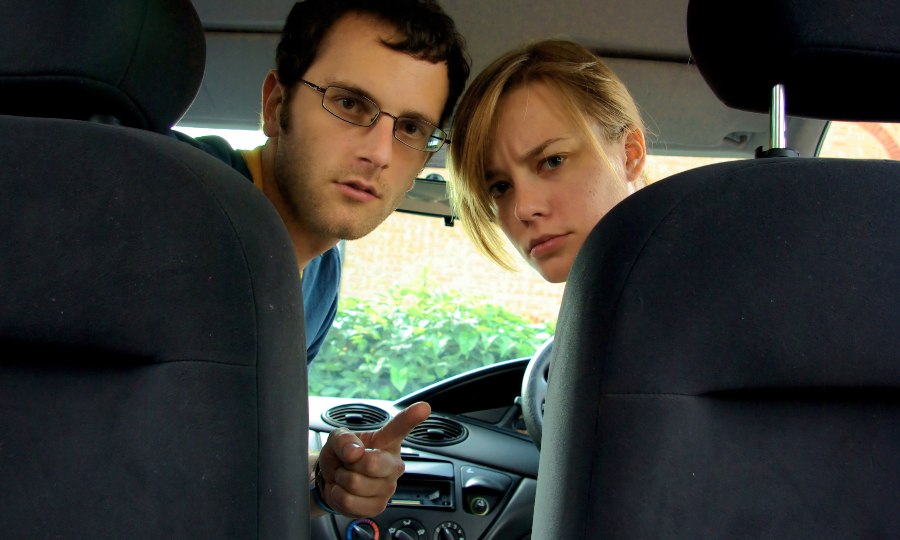 Are We There Yet? Is This a Potential Rally concept photo shows young parents looking angrily into back seat of car as children bicker.
