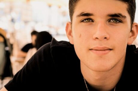 Teaching Teens Financial Responsibility photo concept with male teenager looking toward camera.