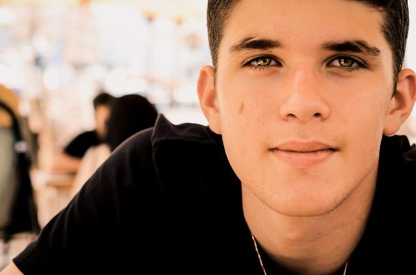 Teaching Teens Financial Responsibility photo concept with male teenager looking toward camera.