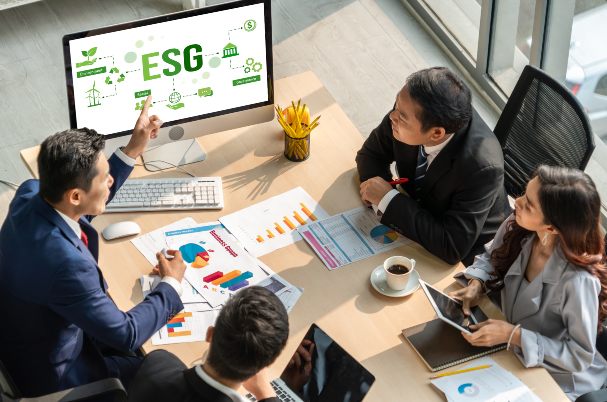 Financial team looks at screen with ESG on it and discusses Unpacking the Controversy Around ESG Investing