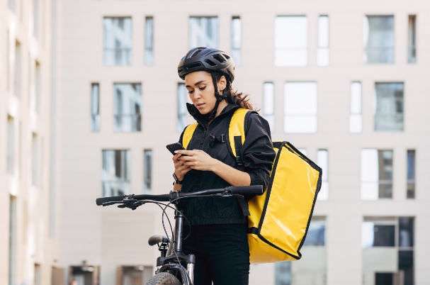 Ways to Reduce Your Tax Liability depicted by Woman courier with backpack checking information for delivery in the city